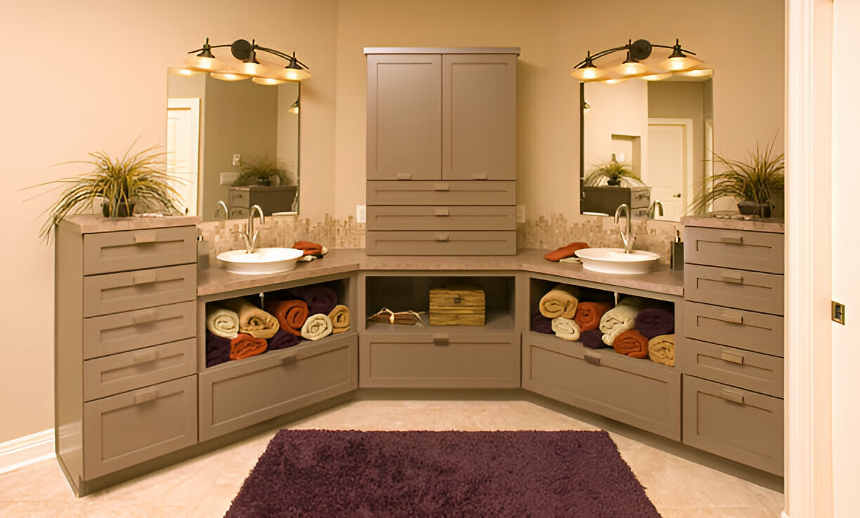 Modern corner bathroom vanity with two sinks, taupe cabinetry, storage drawers, open towel shelving, dual mirrors, and industrial lighting