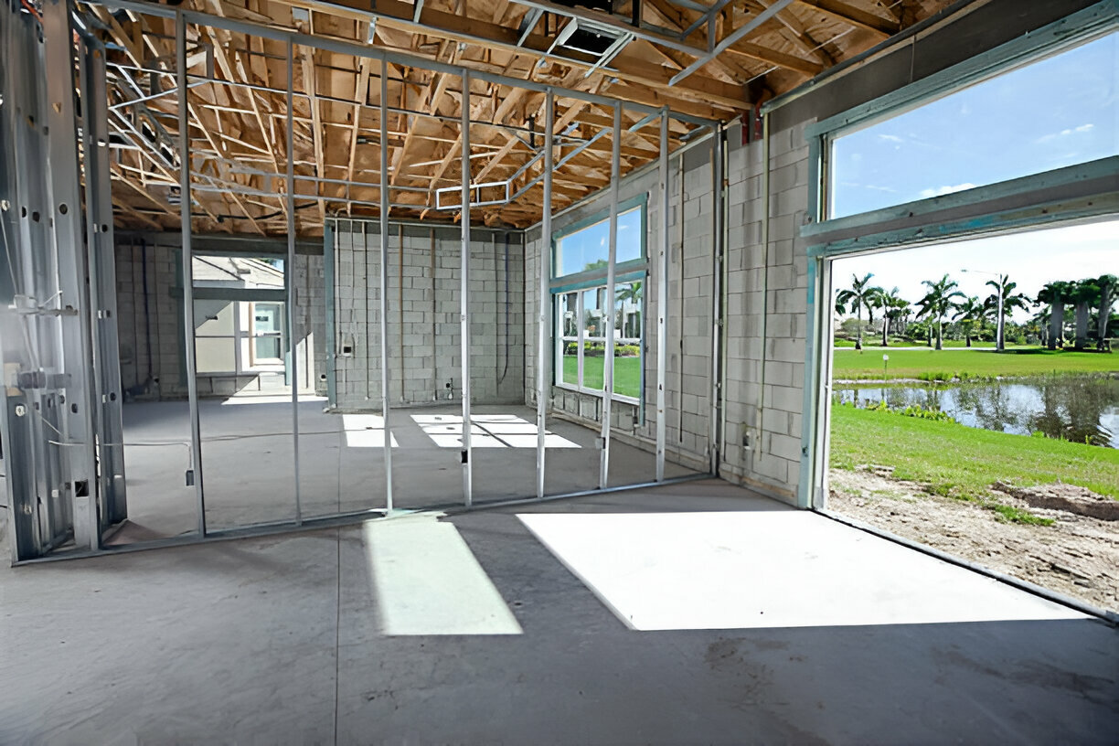 Framed interior of a new home construction with concrete block walls and open windows