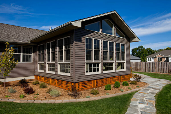 Modern sunroom addition with large windows on residential home