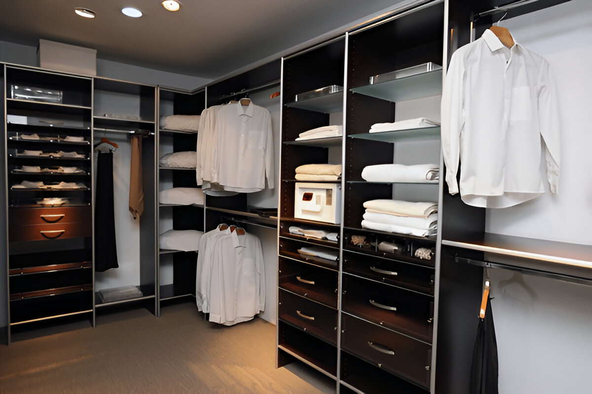 Contemporary walk-in closet with dark wood shelves and hanging shirts.