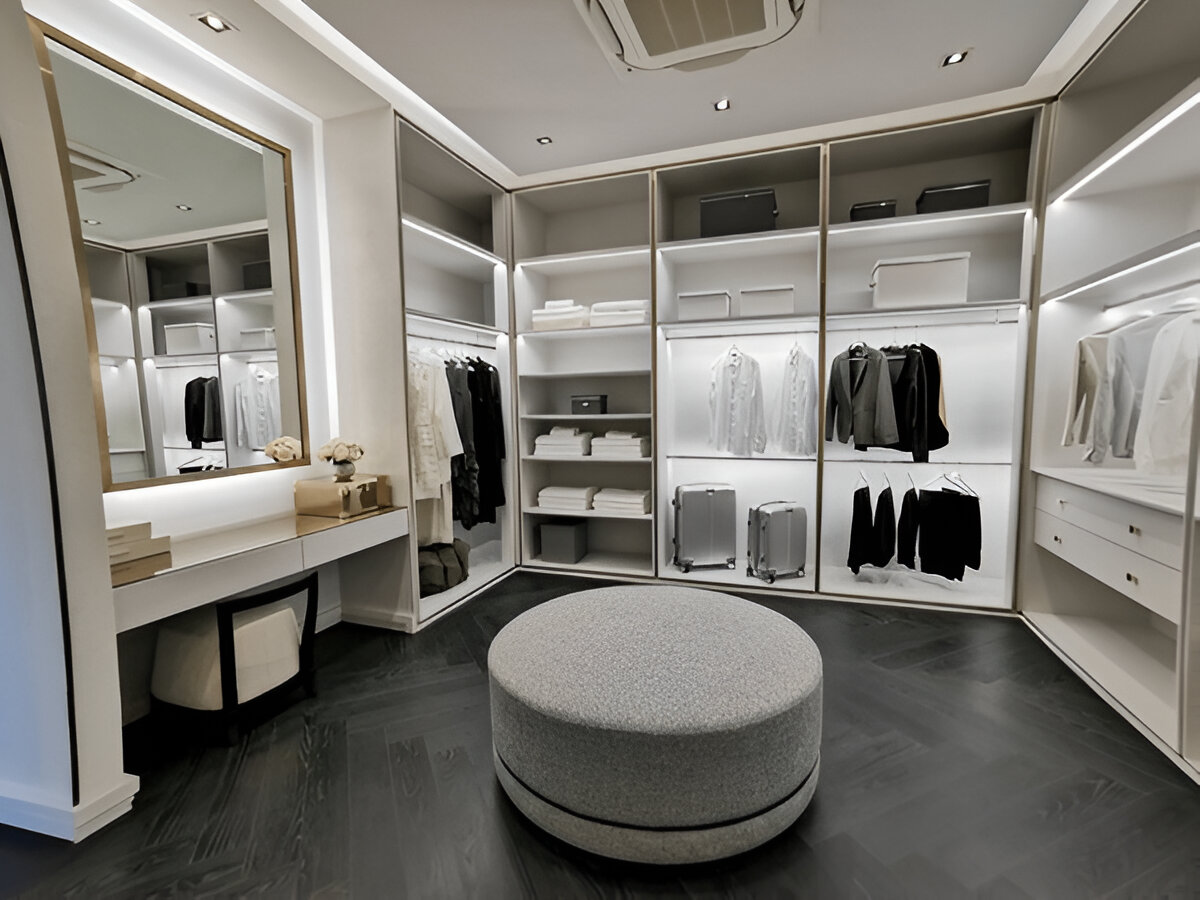 Modern luxury walk-in closet with central ottoman, vanity table, and organized storage.