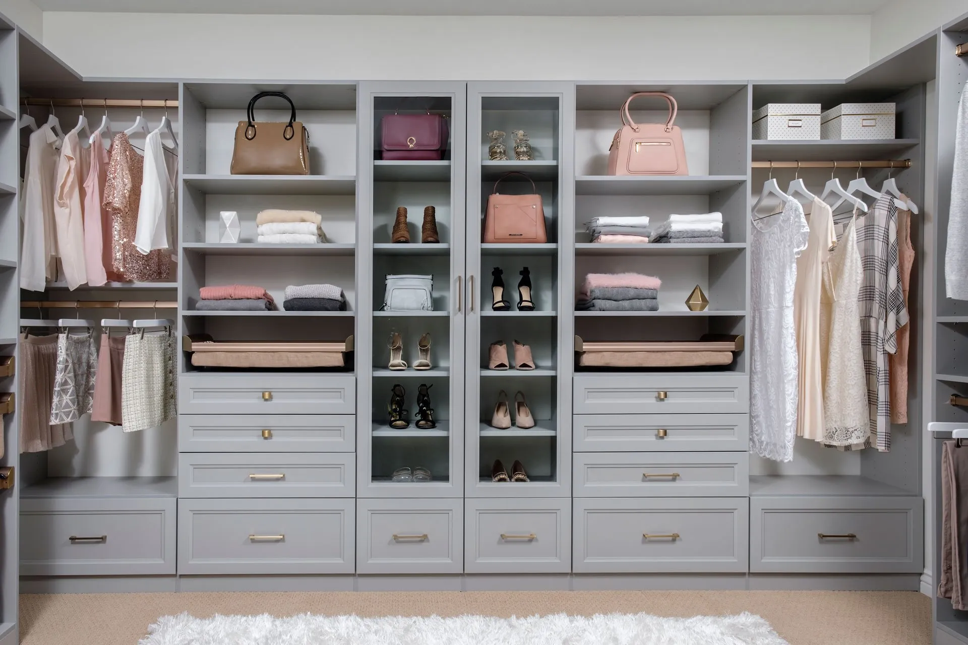 Elegant custom closet with gray cabinetry and organized shelving