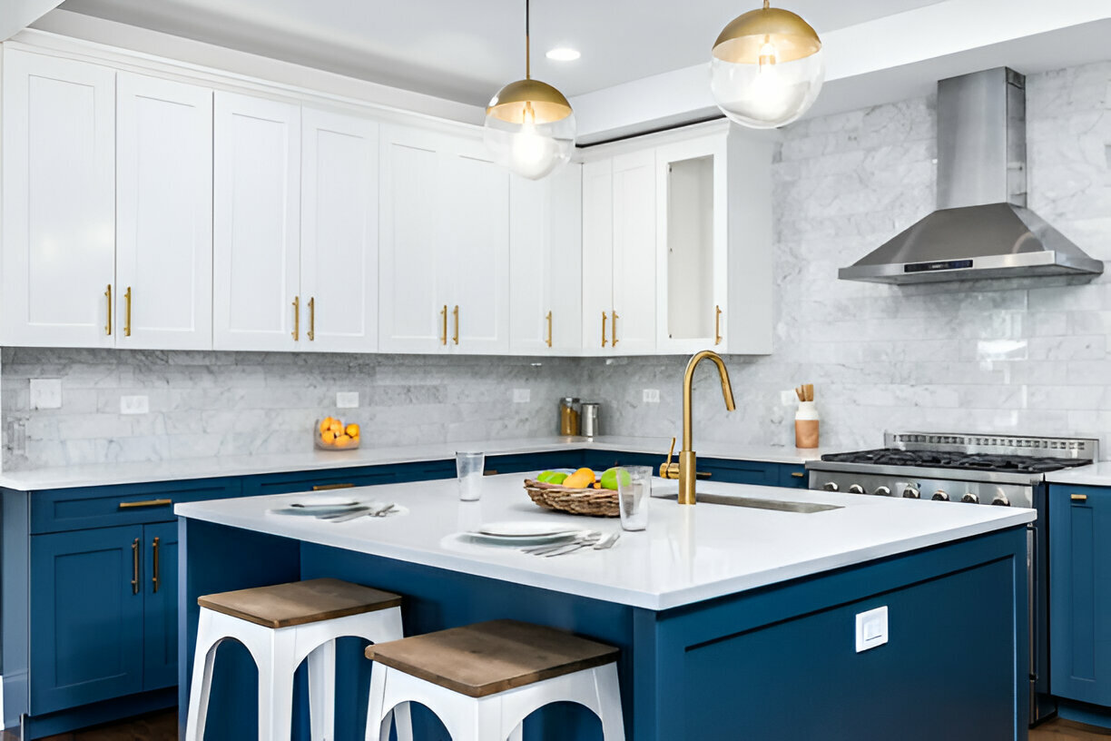 Blue and white kitchen with gold hardware and marble backsplash