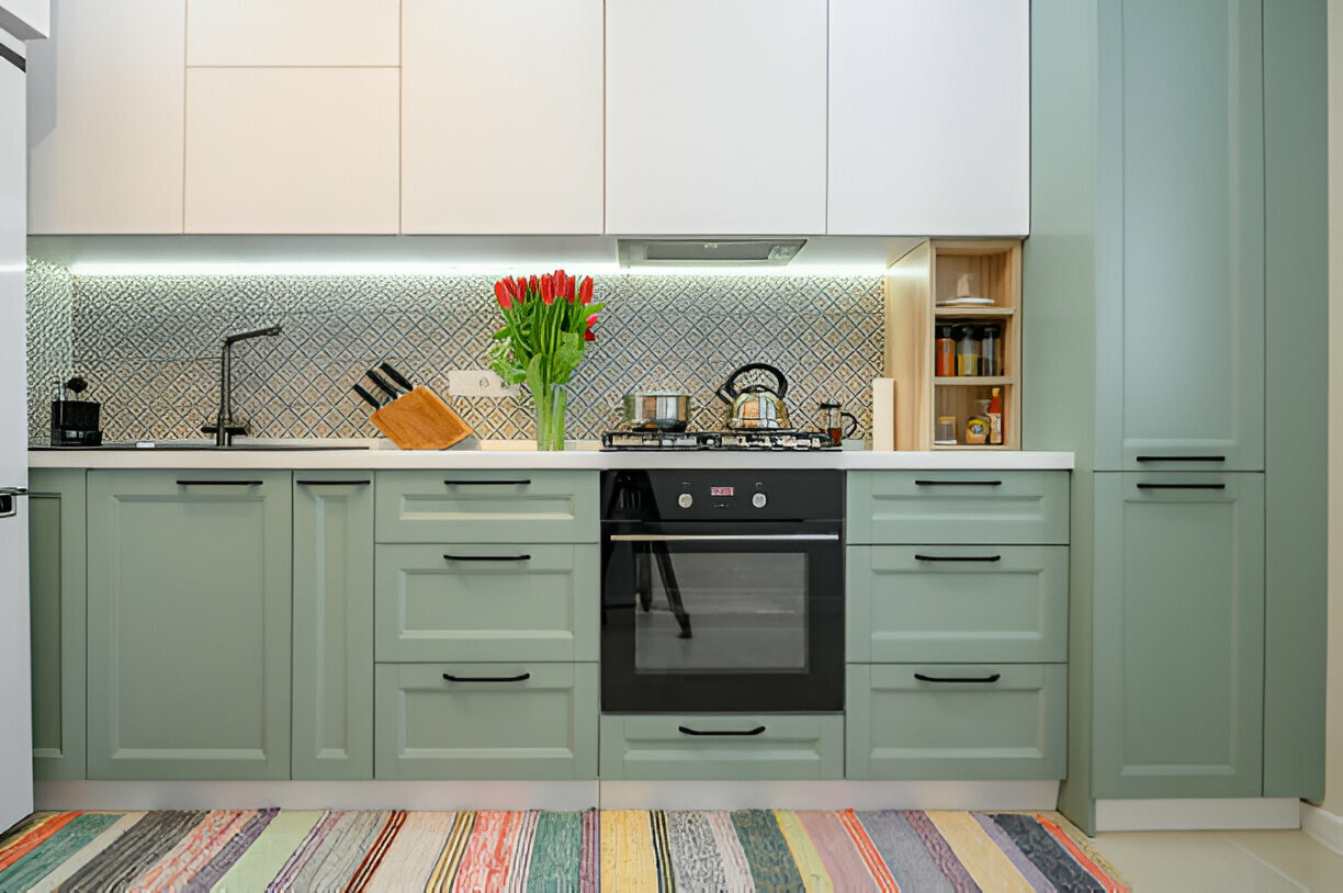 Mint green kitchen cabinets with patterned backsplash