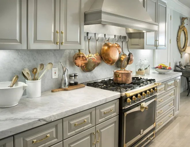 Traditional kitchen with marble countertops, gray cabinets, and copper cookware 
