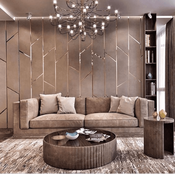 Elegant living room featuring a velvet sofa, geometric PVC wall panels with metallic accents, chandelier, and round coffee table