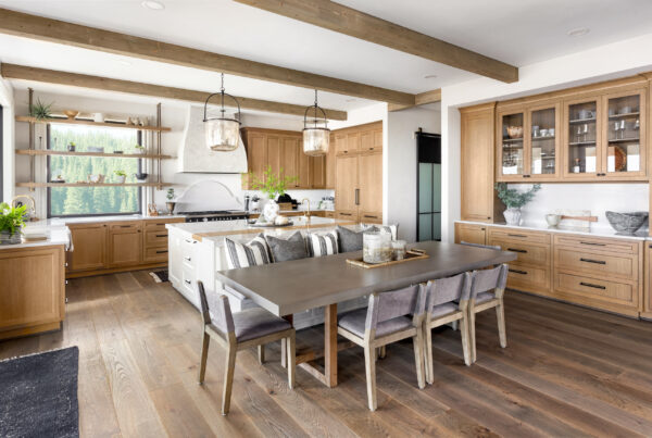 Rustic modern kitchen with wooden cabinets, dining table, and wide plank wood flooring