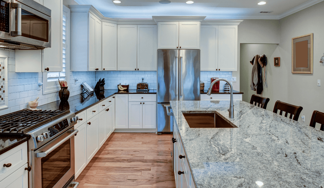  Large kitchen featuring a granite island countertop, white shaker cabinets, stainless steel appliances, and subway tile backsplash.