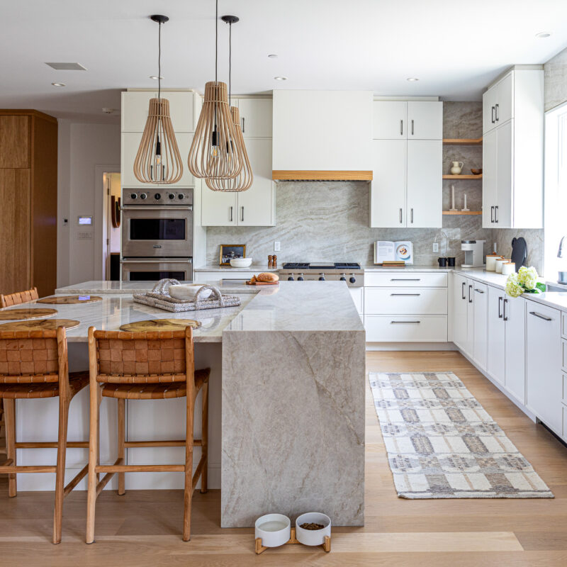 Modern white kitchen with marble island and natural wood accents