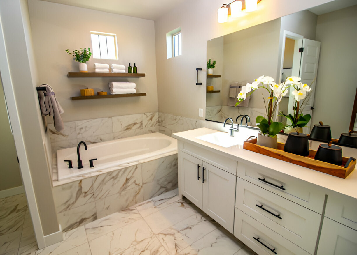 Bright modern bathroom with white double vanity, two round mirrors, sleek black fixtures and a compact toilet. 