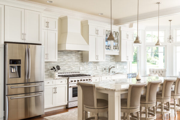 A modern kitchen with stainless steel appliances, a large granite island, and elegant pendant lights hanging above the kitchen counter.
