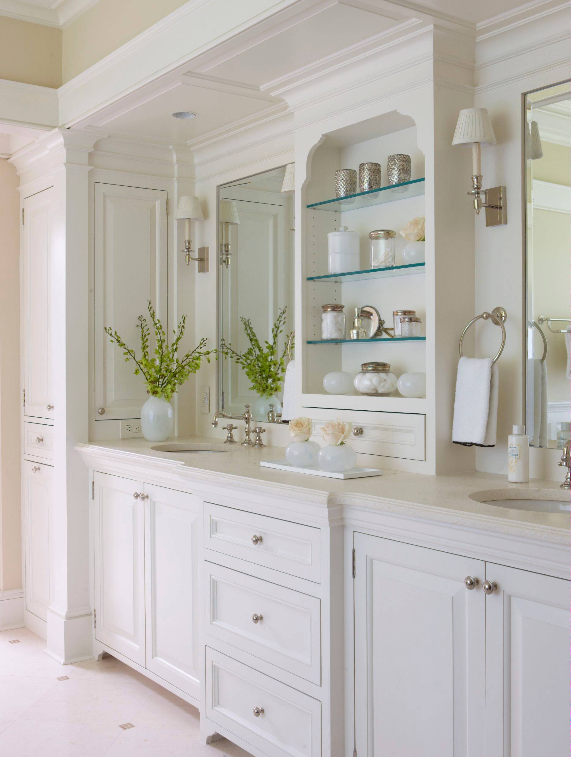 Elegant white bathroom vanity with built-in shelving and decorative accents.