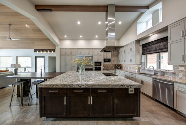 Luxury kitchen with granite island, stainless steel appliances, and modern lighting.