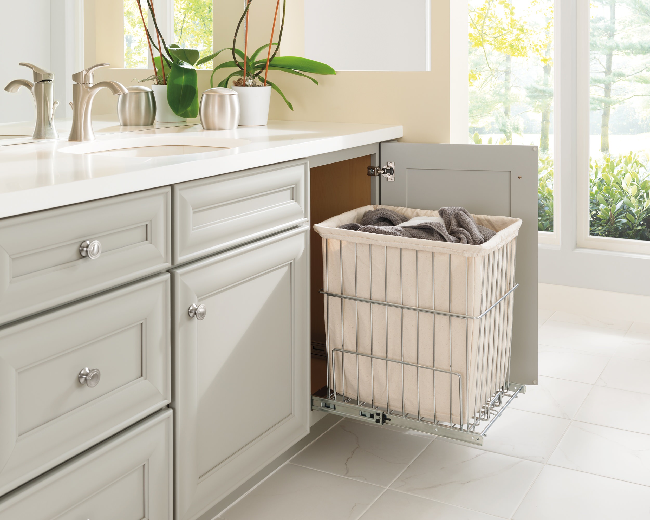Bathroom vanity cabinet with built-in pull-out laundry hamper.