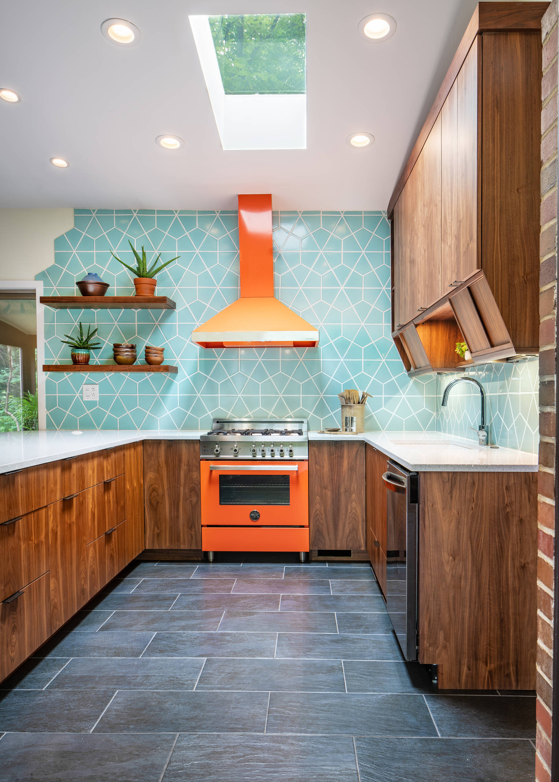 Mid-century modern kitchen with orange appliances and geometric backsplash