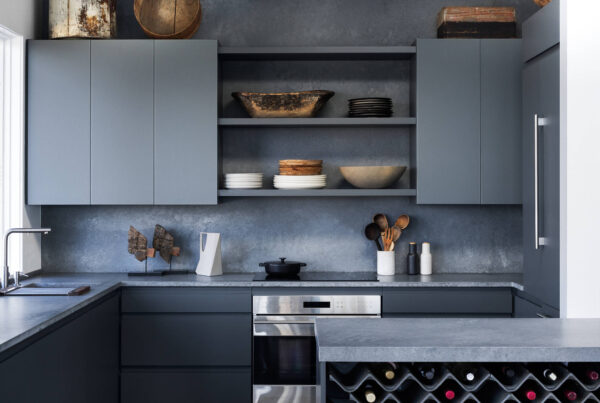 Modern dark-toned kitchen with minimalist cabinets and built-in wine storage.