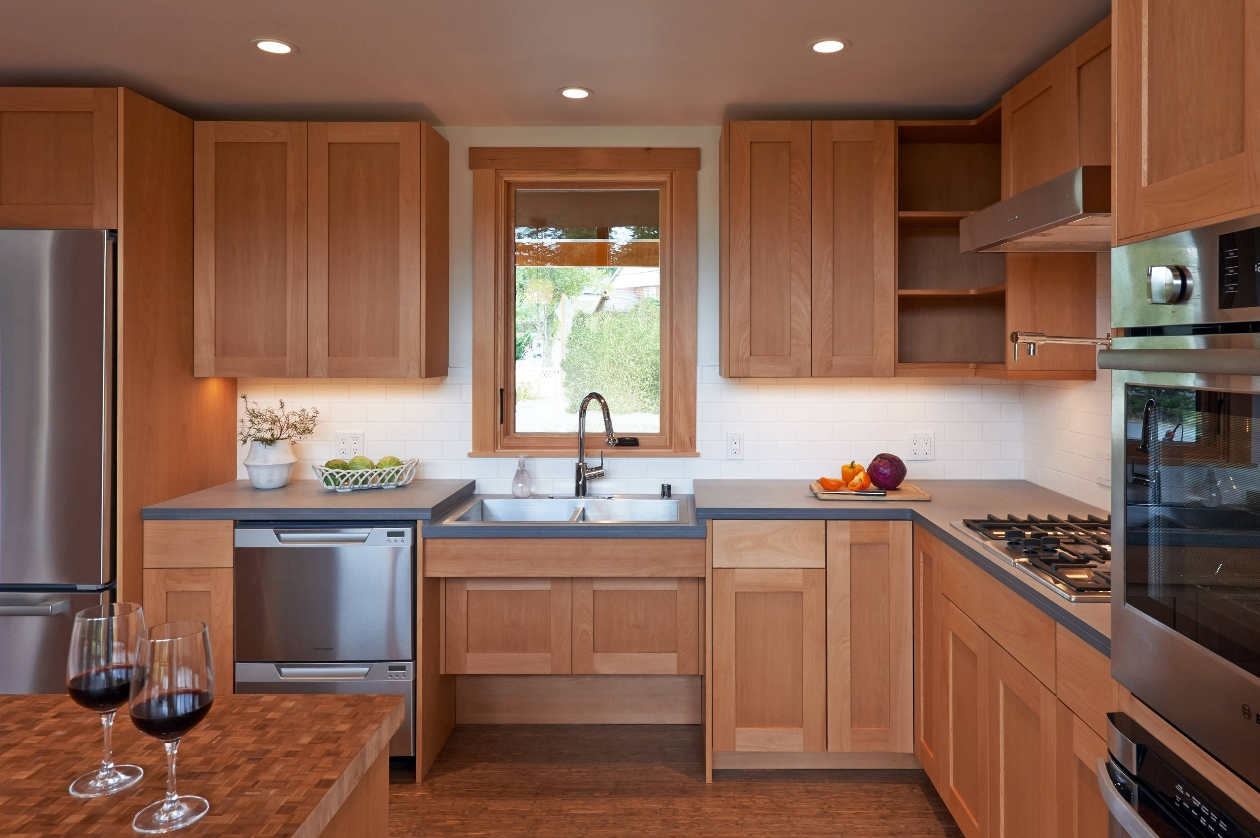 Warm wood kitchen with natural light and modern stainless steel appliances
