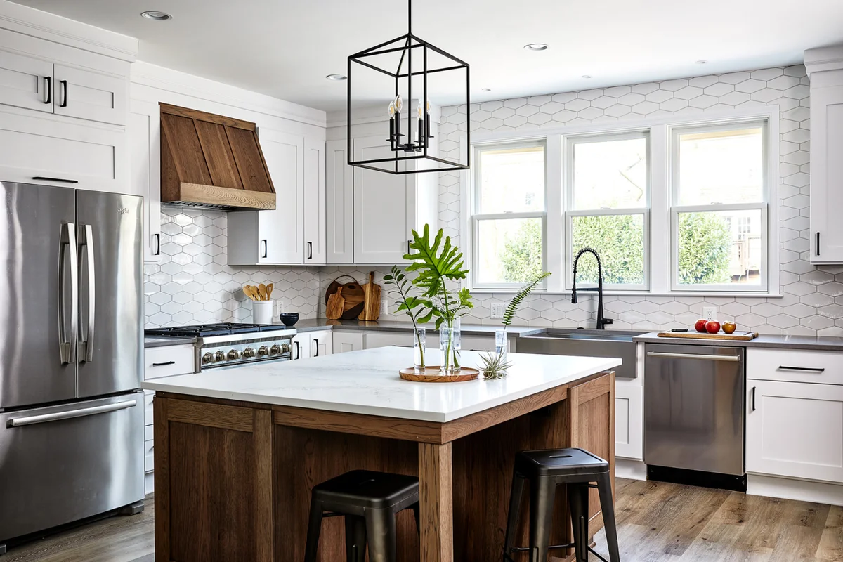 Modern kitchen with white cabinets, wood accents, and stainless steel appliances